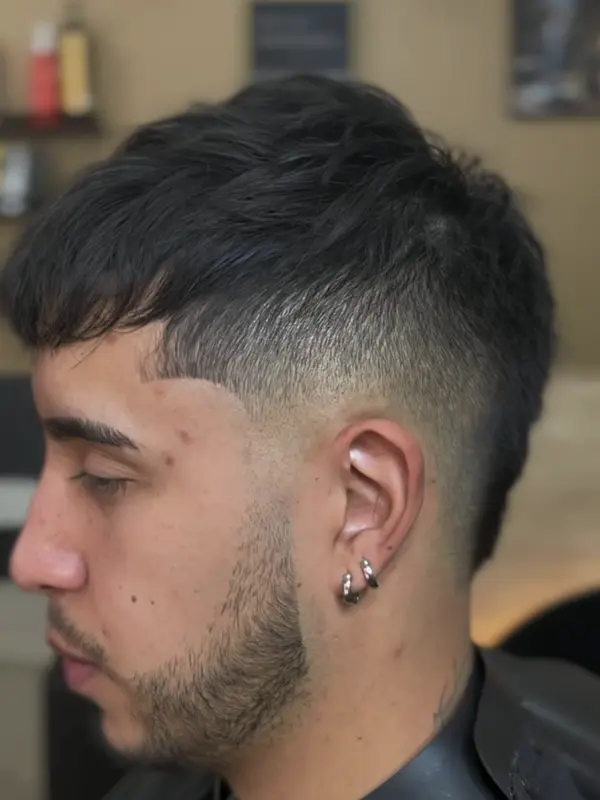 Corte con flequillo y degradado alto, de perfil