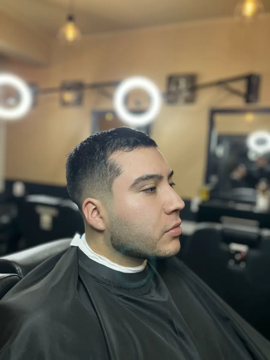 Cliente en el sillón, con los espejos y las luces circulares del local al fondo